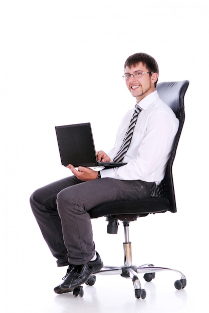 Счастливый бизнесмен на стуле с ноутбуком