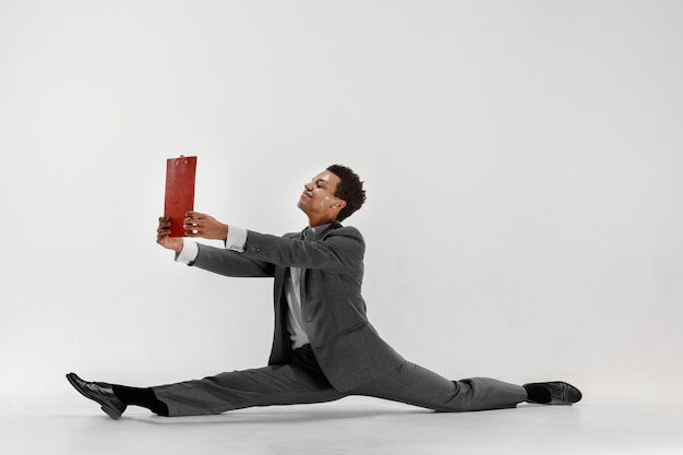 Free photo happy businessman dancing in motion isolated on white studio background. flexibility and grace in business. human emotions concept. office, success, professional, happiness, expression concepts