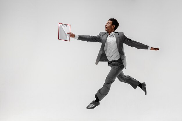 Happy businessman dancing in motion isolated on white studio background. Flexibility and grace in business. Human emotions concept. Office, success, professional, happiness, expression concepts