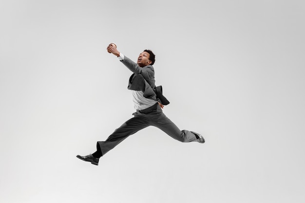 Free photo happy businessman dancing in motion isolated on white studio background. flexibility and grace in business. human emotions concept. office, success, professional, happiness, expression concepts