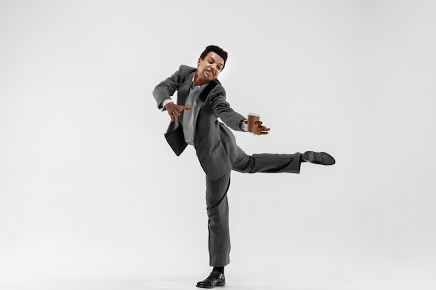 Happy businessman dancing in motion isolated on white studio background. Flexibility and grace in business. Human emotions concept. Office, success, professional, happiness, expression concepts