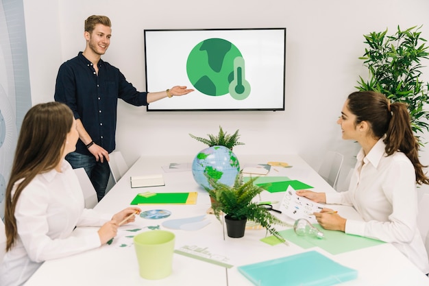 Free photo happy businessman giving presentation on global warming to his female colleagues