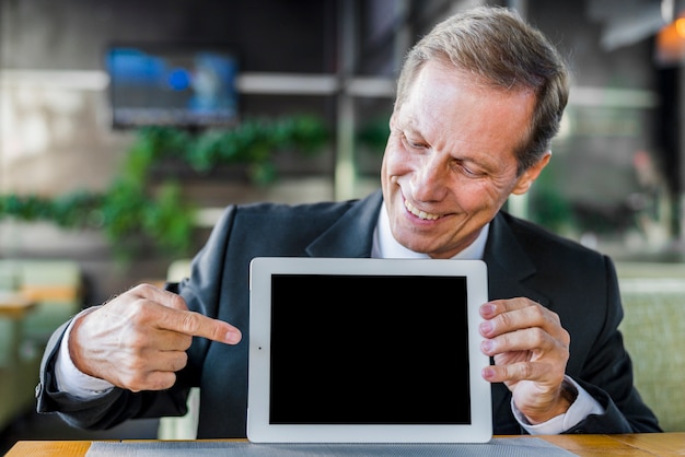 디지털 태블릿의 빈 화면에서 가리키는 행복 한 사업가