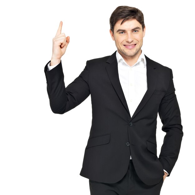 Happy businessman points his finger up in black suit isolated on white