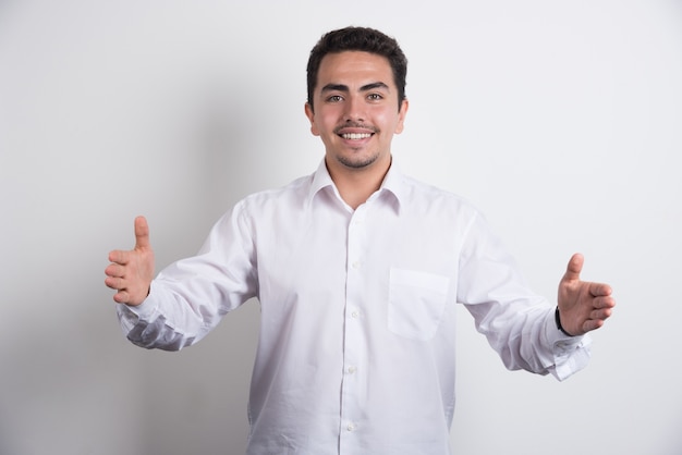 Happy businessman showing his hands on white background.