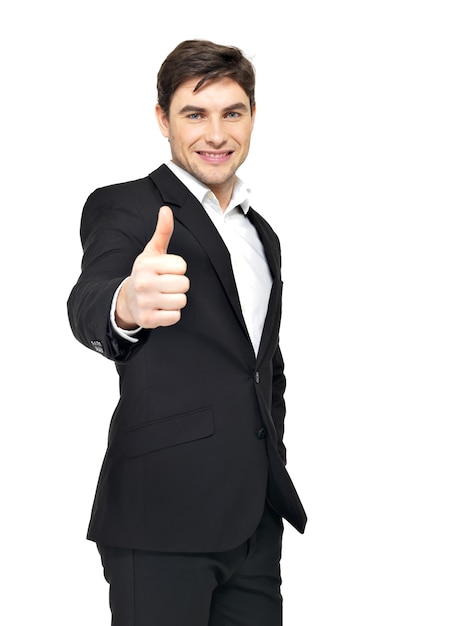 Happy businessman shows thumbs up sign in black suit isolated on white.