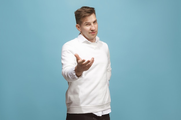 The happy businessman standing and smiling against blue background.