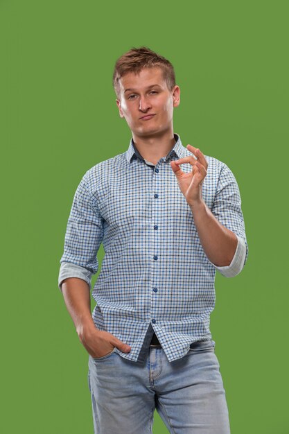 Free photo the happy businessman standing and smiling against green wall