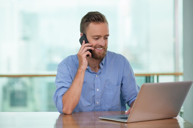 Happy businessman talking on the phone to client