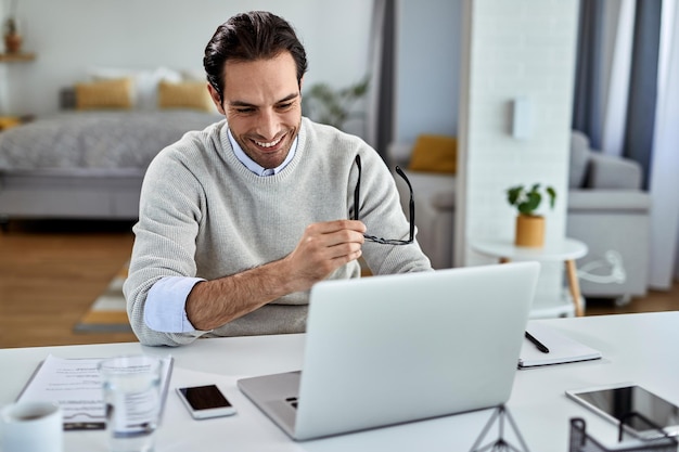 Happy businessman using computer while working at home