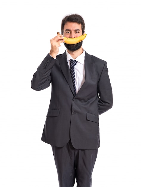 Happy businessman with banana over white background