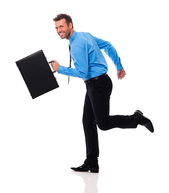 Happy businessman with briefcase running