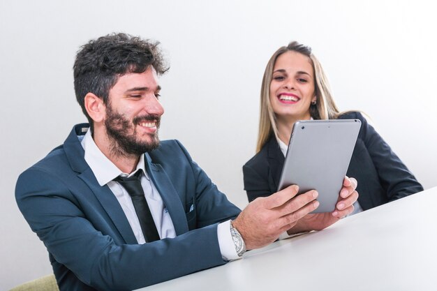 Happy businesspeople looking at digital tablet