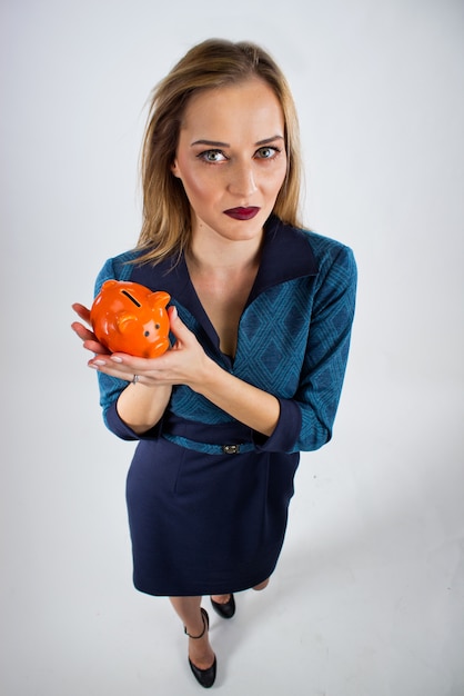 Happy businesswoman holding piggy bank against white background. Safings concept holding piggy bank top view.