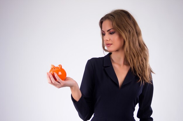 Happy businesswoman holding piggy bank against white background