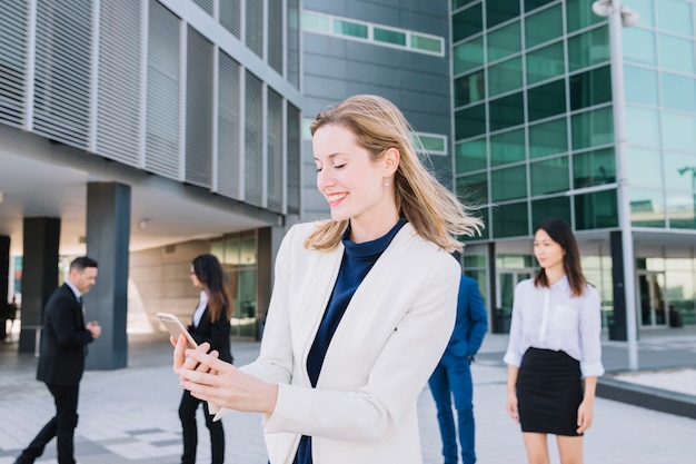 Happy businesswoman looking at smartphone