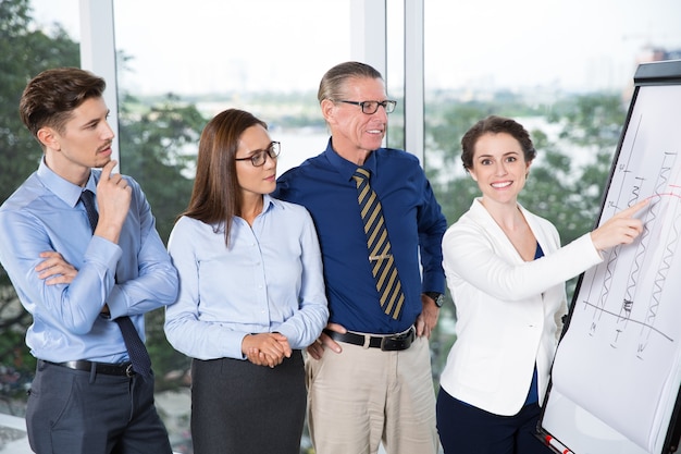 Happy Businesswoman Presenting Chart to Colleagues