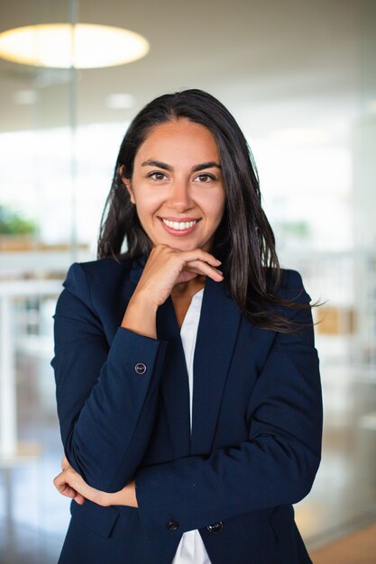 Happy businesswoman with hand on chin