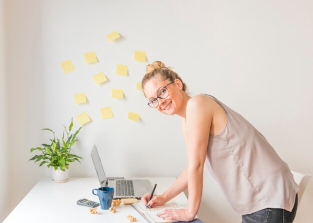 Free Photo happy businesswoman writing schedule in diary