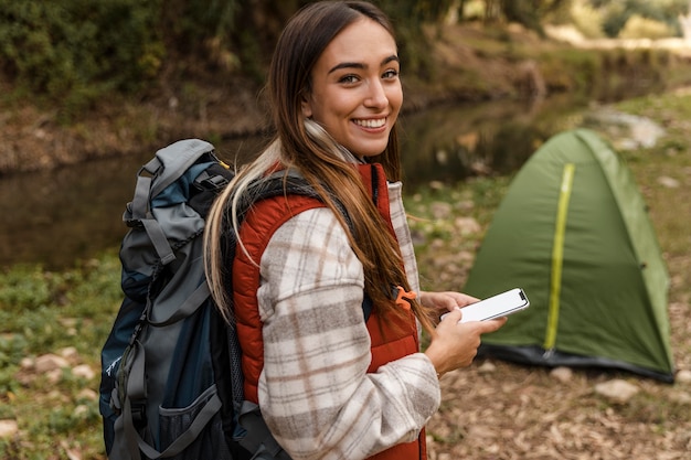 Happy camping girl in the forest and tent high view