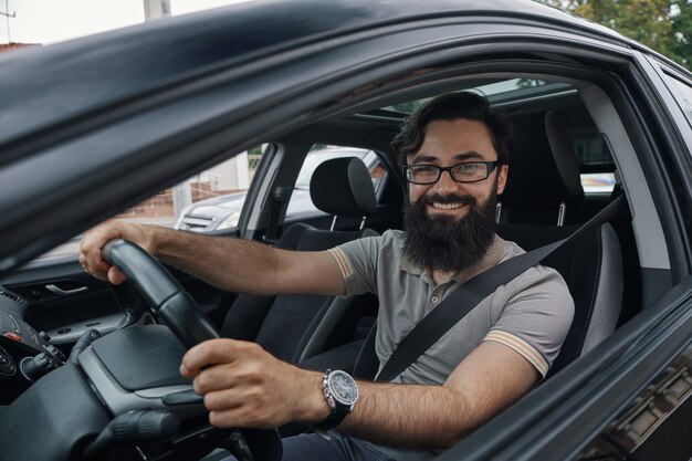 Happy car driver with fastened seat belt