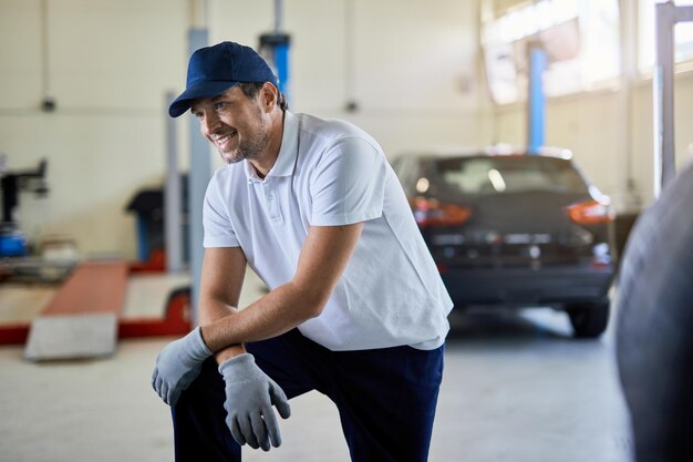 自動車修理店で働いている間休んでいる幸せな自動車整備士