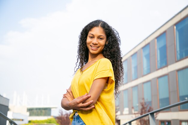 Happy carefree curly haired woman posing