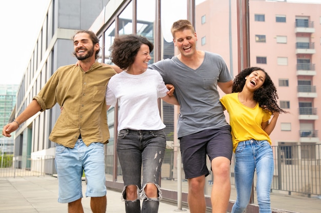 Happy carefree friends walking outside and having fun