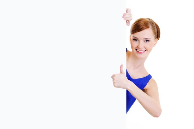 Happy casual girl  with a blank banner showing thumbs-up