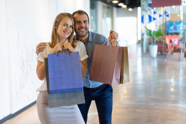 Free photo happy caucasian couple doing shopping in outlet mall.