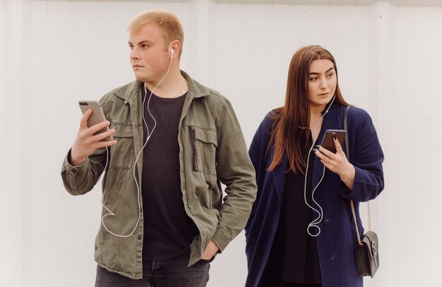 Happy Caucasian couple using a Smart Phone outdoors in the city