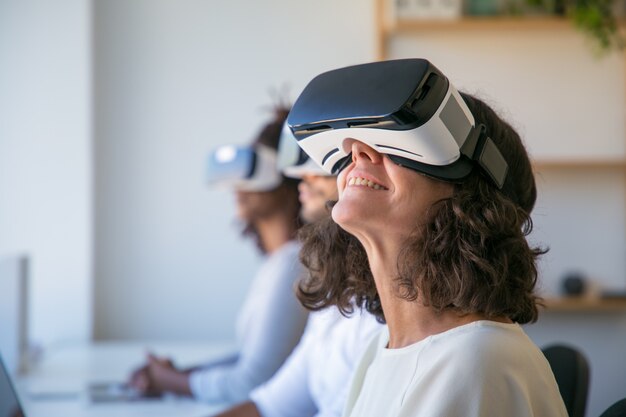 Happy Caucasian woman in VR glasses enjoying experience