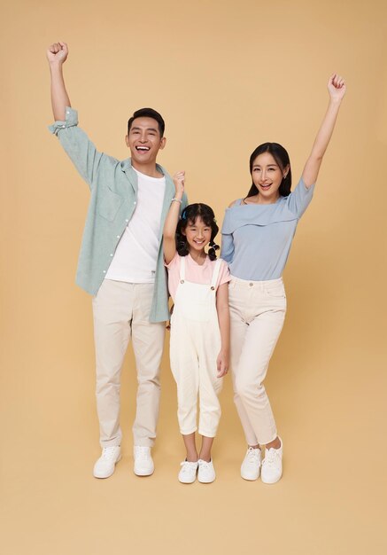 Счастливый праздник азиатский родительский семейный портрет стоя с поднятыми руками