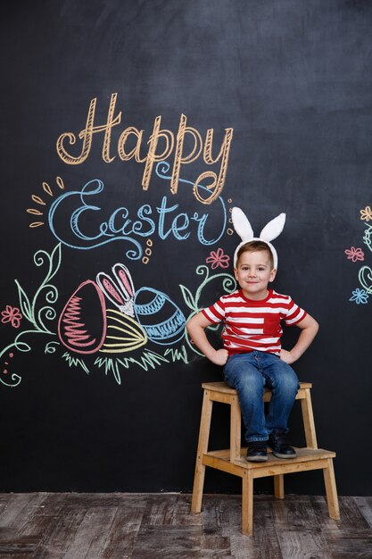 Счастливый веселый маленький мальчик носить уши кролика и праздновать Пасху
