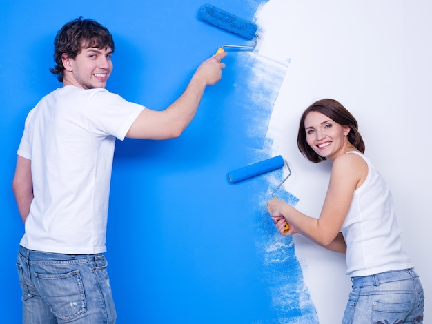파란색으로 벽을 솔질 행복 쾌활한 젊은 부부