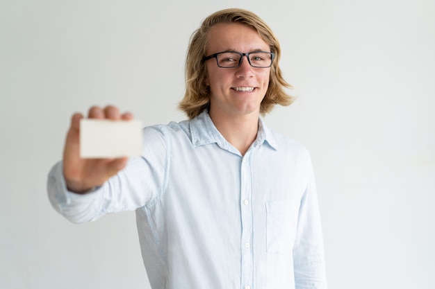 Happy cheerful young leader showing business card