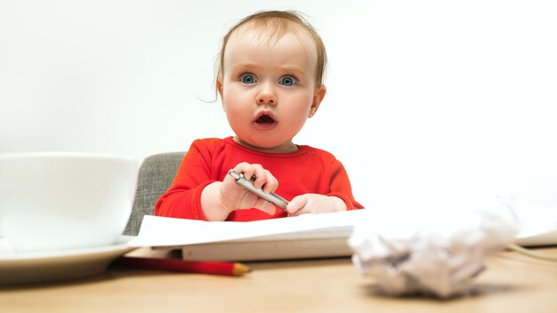 現代のコンピューターのキーボードまたは白いスタジオでラップトップで座っている幸せな子供女の赤ちゃん