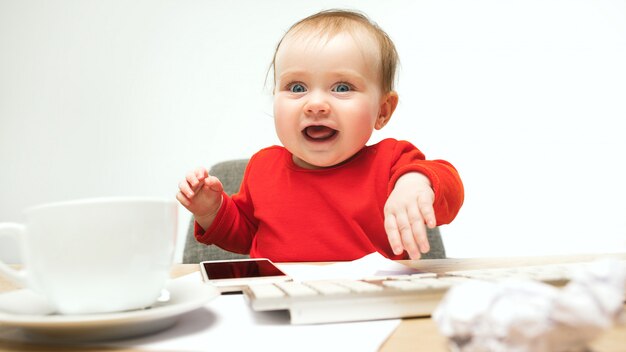 고립 된 컴퓨터의 키보드에 앉아 행복 한 아이 아기 소녀 유아