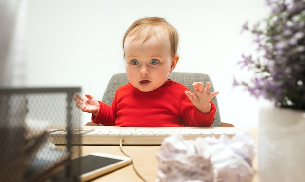 分離されたコンピューターのキーボードで座っている幸せな子供赤ちゃん女の子幼児