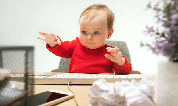 分離されたコンピューターのキーボードで座っている幸せな子供赤ちゃん女の子幼児