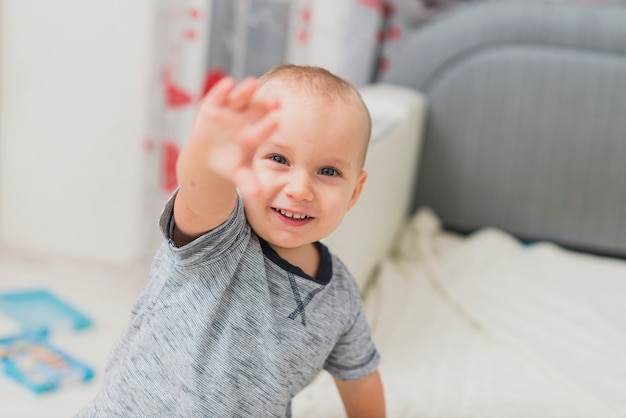 Foto gratuita bambino felice con la mano alzata