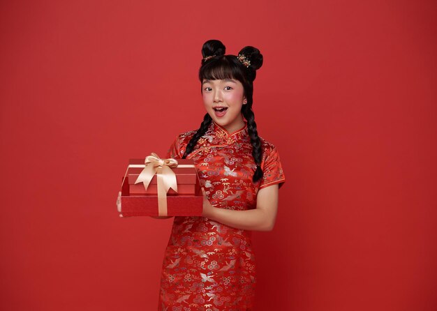 은 전통 의상을 입은 아시아 소녀가 중국 신년 축복을 위해 선물 상자를 선물합니다.