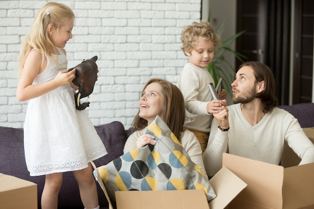 Счастливые дети помогают родителям распаковывать коробки в день переезда