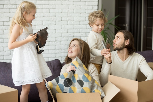 Free photo happy children helping parents to unpack boxes on moving day