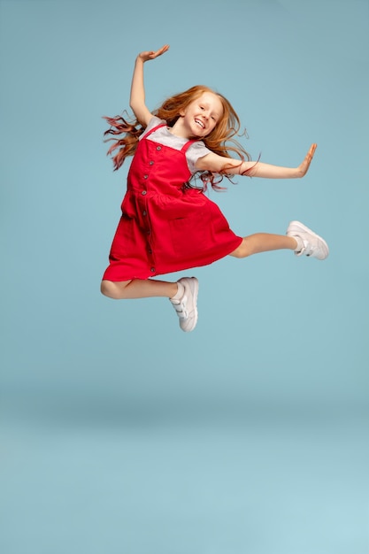 Free photo happy children isolated on blue studio background. looks happy, cheerful, sincere. copyspace. childhood, education, emotions concept