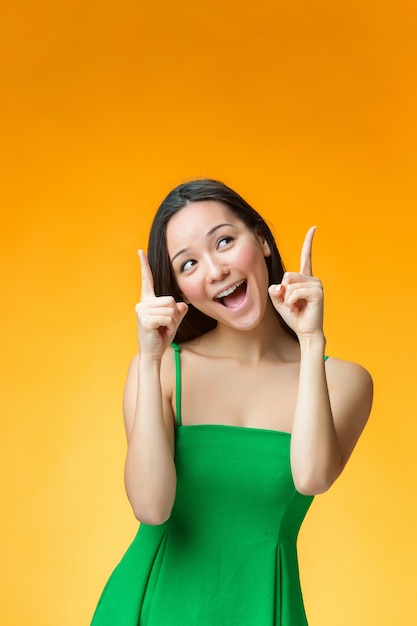 The happy Chinese girl on yellow background