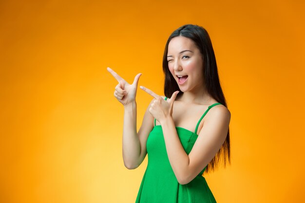 The happy Chinese girl on yellow background