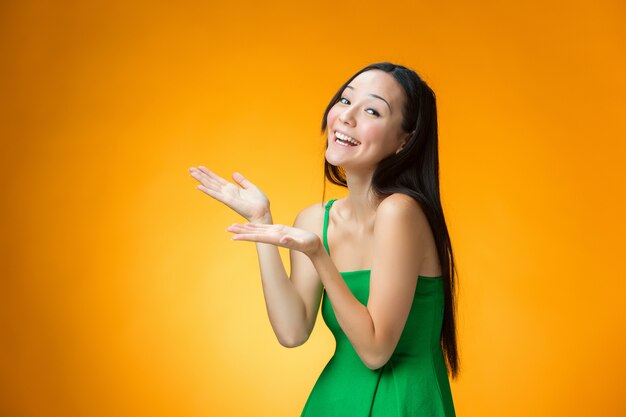 The happy Chinese girl on yellow wall