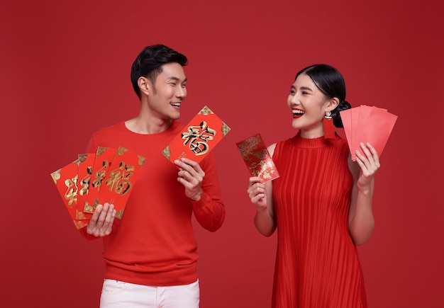 Бесплатное фото Счастливого китайского нового года азиатская пара в красной одежде с ангпао или красным пакетом денежных подарков