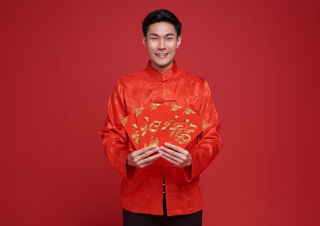 Бесплатное фото С китайским новым годом азиатский мужчина держит ангпао или красный пакет денежного подарка